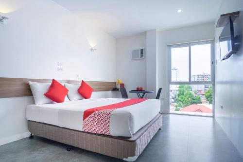 1 dormitorio con 1 cama grande con almohadas rojas en 18 Suites Cebu, en Cebú