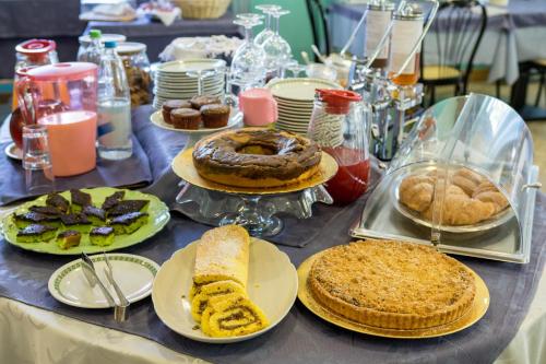 a table topped with different types of cakes and pies at Hotel Solidea in Rimini