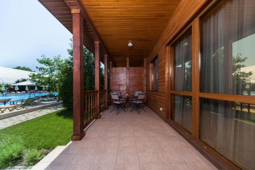 a porch of a house with a table and chairs at Kompleks Otdykha Elki-Palki in Odesa