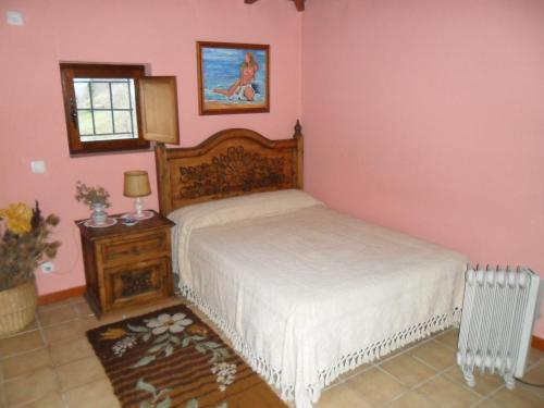una camera rosa con un letto di Casa Rural La Rectoral De Tuiza a Tuiza de Arriba