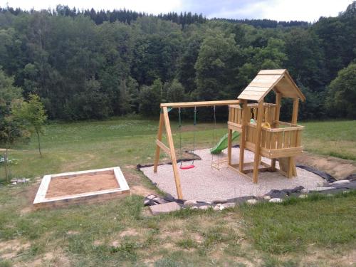 a playground in a field with a swing at Apartmány U Žaloudků in Dolní Morava