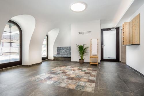 an empty room with a potted plant in the middle at JUFA Alpenhotel Saalbach-Jokercard im Sommer inklusive in Saalbach Hinterglemm
