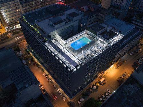 an overhead view of a large building with a swimming pool at Capsis Hotel Thessaloniki in Thessaloniki