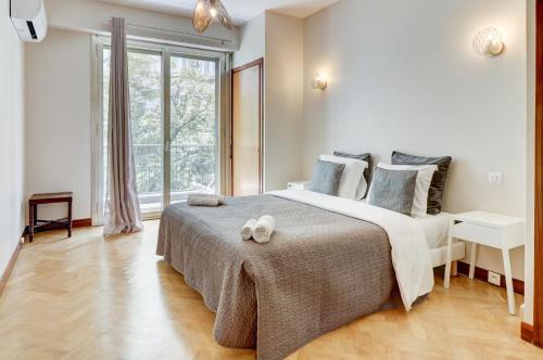 une chambre avec un grand lit et une grande fenêtre dans l'établissement PROMENADE HOLIDAY - PALATIN PROMENADE, à Nice