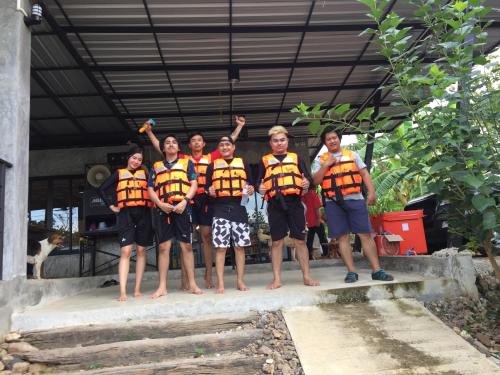 a group of people wearing life jackets standing on steps at ชลลดา ริเวอร์ โฮมสเตย์ แก่งกระจาน in Ban Wang Malako