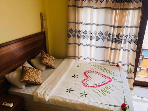 a bedroom with a bed with a happy new year sign on it at Mariana Maldives in Gaafaru