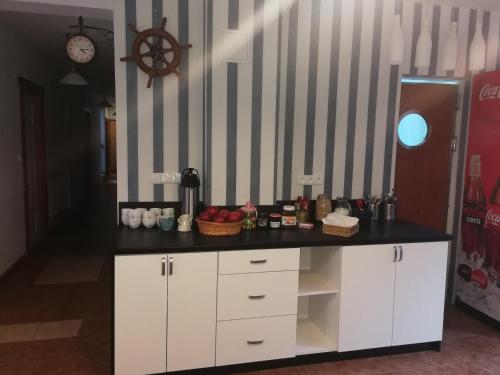 a kitchen with white cabinets and a black counter top at Cicha Dolinka in Stegna