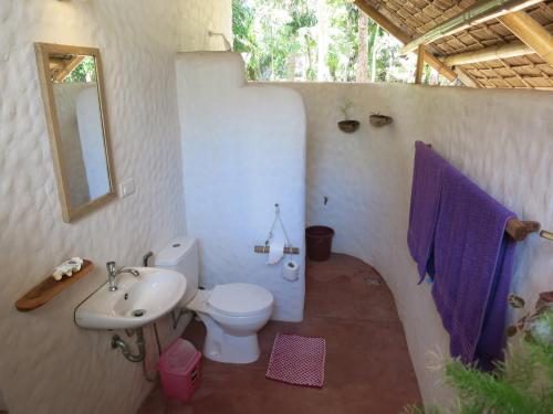 a bathroom with a toilet and a sink and a mirror at Sugar Lounge Lodge in Nauhang