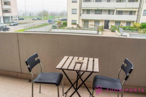 einen Holztisch und Stühle auf dem Balkon in der Unterkunft casa vacanze da Nico in Parma
