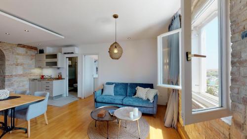 a living room with a blue couch and a table at Riva Apartments in Split