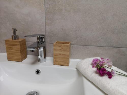 a bathroom sink with a faucet and flowers on it at Grzybowo Dom wakacyjny in Grzybowo
