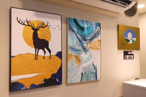 three paintings of a deer on a wall at Lukang Barn Inn in Lugang