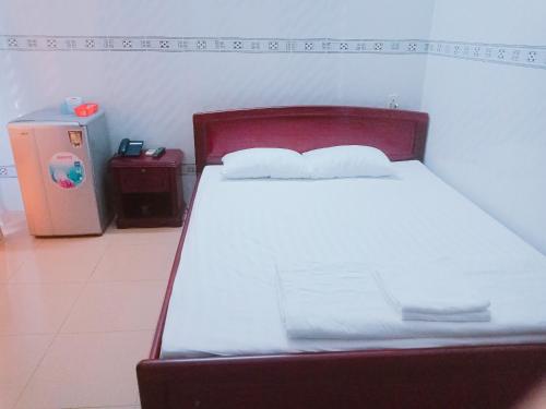 a bed with white sheets and pillows in a room at Khách sạn Kim Phụng Ngân in Can Tho