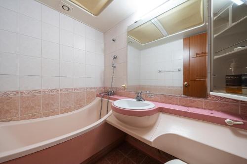 a bathroom with a sink and a tub at Fantastic Ocean View Sydney Hotel in Jeju