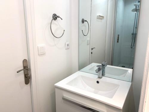 uma casa de banho branca com um lavatório e um espelho em La Chambre Bleue em Saint-Aignan