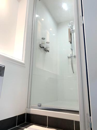 W łazience znajduje się prysznic ze szklanymi drzwiami. w obiekcie La Chambre Bleue w mieście Saint-Aignan