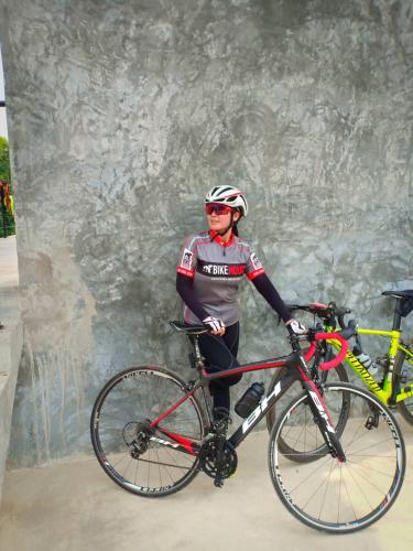 a man standing next to a bike in front of a wall at ชลลดา ริเวอร์ โฮมสเตย์ แก่งกระจาน in Ban Wang Malako