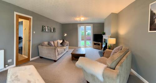 a living room with two chairs and a tv at Dwarwick House in Thurso
