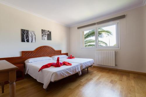 a bedroom with two beds with red bows at Villa Alzina alojamiento vacacional a 10 minutos de la playa de Cala Millor, Mallorca in Cala Millor