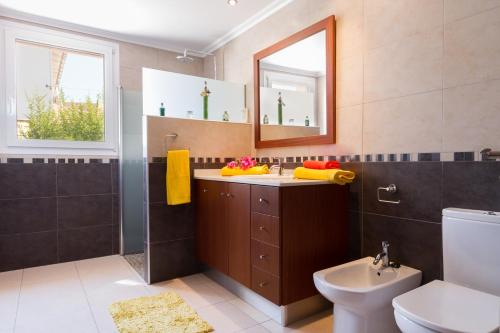 a bathroom with a sink and a toilet and a mirror at Villa Alzinita in Cala Millor