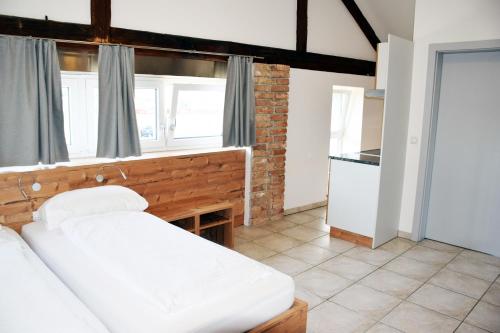 a bedroom with a white bed and a kitchen at Apartment´s Marchtrenk in Marchtrenk