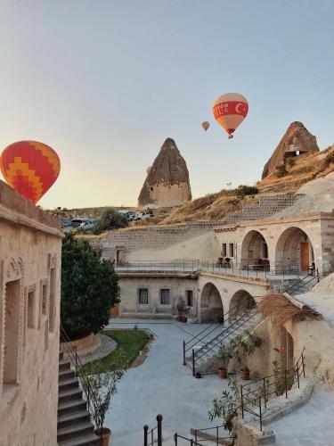 two hot air balloons flying over a building at Lunar Cappadocia Hotel in Goreme