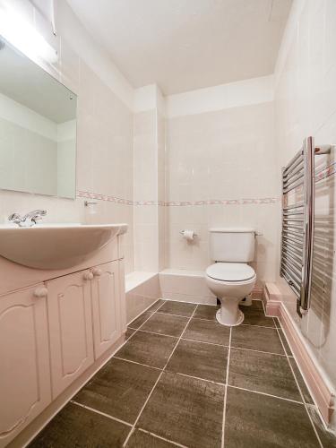 a white bathroom with a sink and a toilet at The Bridge House Hotel in Reigate