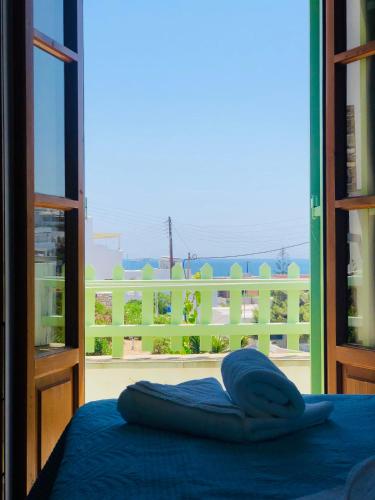 a bed in a room with a view of a balcony at Elena Studios & Apartments in Piso Livadi