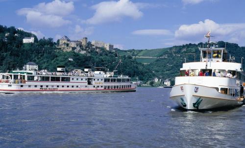 two boats on the water with a castle in the background at Wyndham Garden Lahnstein Koblenz in Koblenz