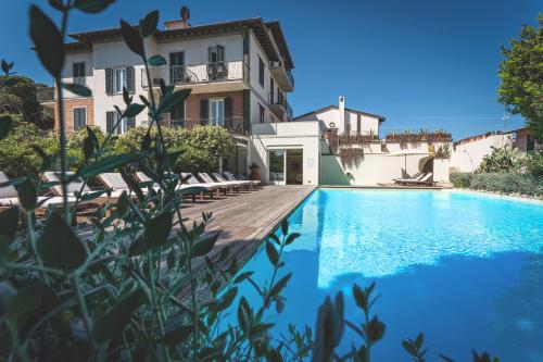 a villa with a swimming pool in front of a house at Villa Martini in Castiglioncello