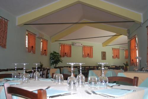 una sala da pranzo con tavolo e bicchieri da vino di Punto Di Ristoro Uttolo a Baunei