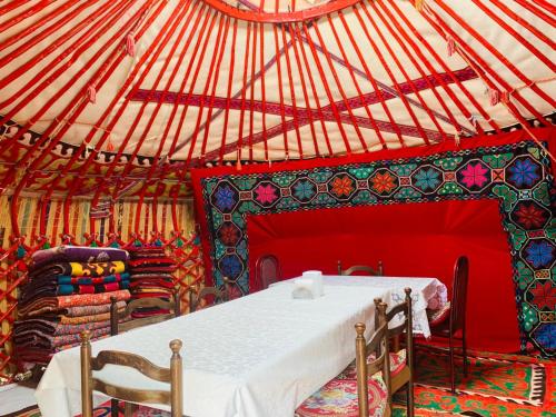 a room with a table and chairs in a yurt at Guest House Aiym in Bokonbayevo