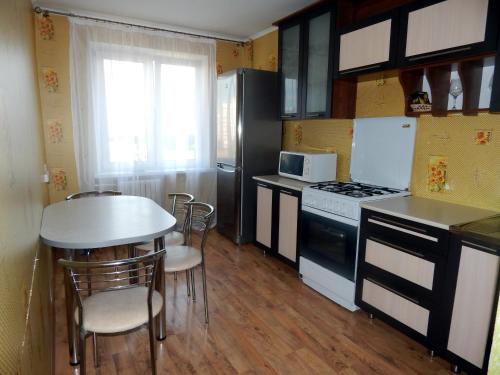 a kitchen with a table and a stove top oven at Apartment 18 Microrayon in Zhlobin