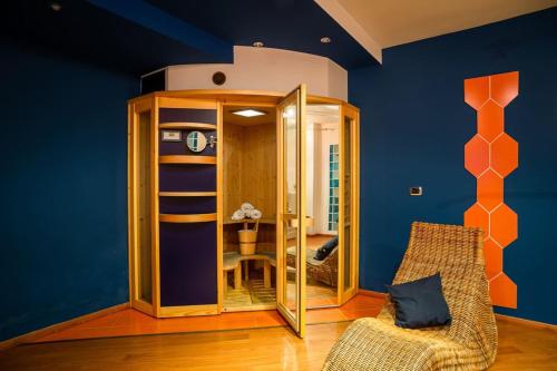 a room with blue walls and a chair and a clock at Villa Sequoia in Leinì