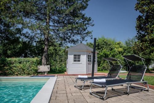 two lounge chairs sitting next to a swimming pool at Villa Sequoia in Leinì