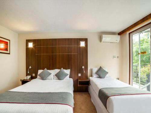 a hotel room with two beds and a window at The Bridge House Hotel in Reigate