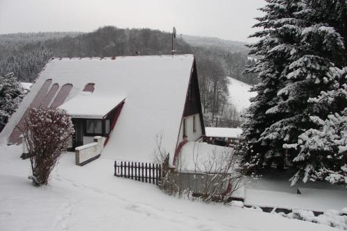 a house covered in snow with a fence at Edy Dum in Svoboda nad Úpou