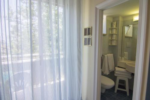 bagno con servizi igienici, lavandino e finestra di Hotel Solidea a Rimini