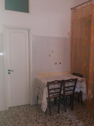 a room with a table and two chairs and a door at Monolocale in via San Sebastiano Ficarra in Ficarra