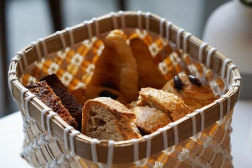 una cesta llena de pan y bollería en una mesa en Hôtel & Restaurant Sodade, en Chaudes-Aigues