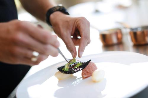 a person eating a piece of food on a plate at Gl Skovridergaard in Silkeborg