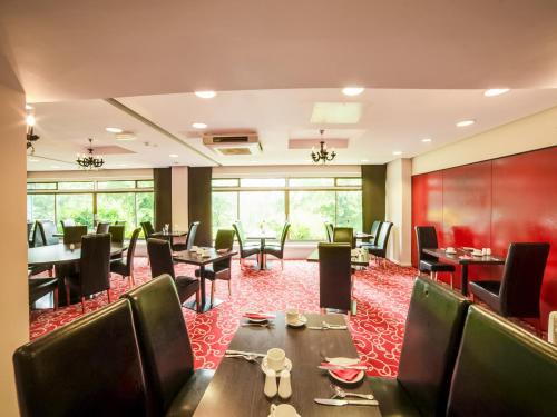 a restaurant with tables and chairs and a red carpet at The Bridge House Hotel in Reigate