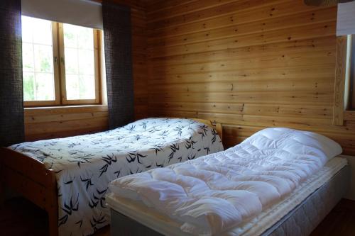 una camera con 2 letti in una baita di tronchi di Martinmäki a Virrat