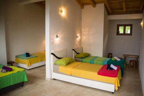 two beds in a room with yellow and green at Adriatrek Bed & Breakfast in Petrovac na Moru
