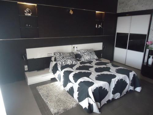 1 dormitorio con edredón blanco y negro en una cama en CASA RURAL LA SUITE DE ALMAGRO en Almagro