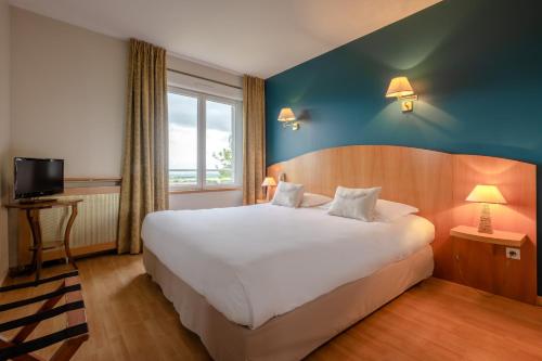 เตียงในห้องที่ Auberge du Poids Public Logis Hotel