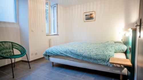 une chambre avec un lit, une chaise et une fenêtre dans l'établissement Appartement Denim, à Nîmes