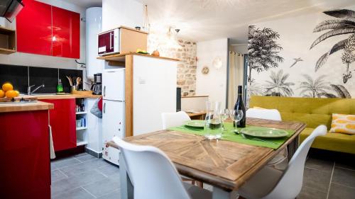 eine Küche und ein Esszimmer mit einem Holztisch und Stühlen in der Unterkunft Appartement Denim in Nîmes