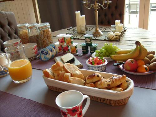 einen Tisch mit einem Tablett mit Speisen und Obst in der Unterkunft La Grange de Gournay in  Gournay-Loizé