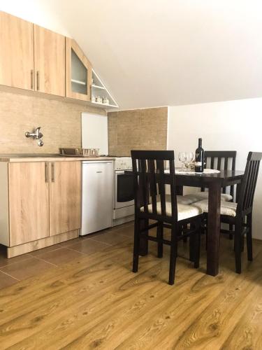 a kitchen with a table and two chairs and a kitchen with a kitchen at Mountain House Tara Apartmani Nikolic in Kaludjerske Bare